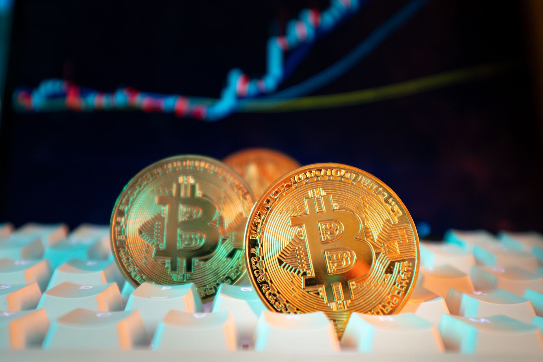 Bitcoin and trading concept shown with coins, pen, and letter tiles on a dark background.