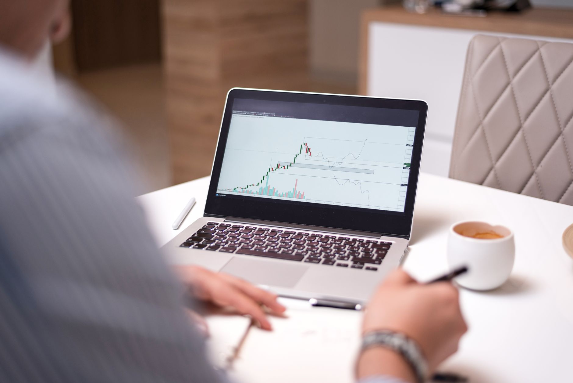 Trader checking Kraken chart on laptop at a desk in London