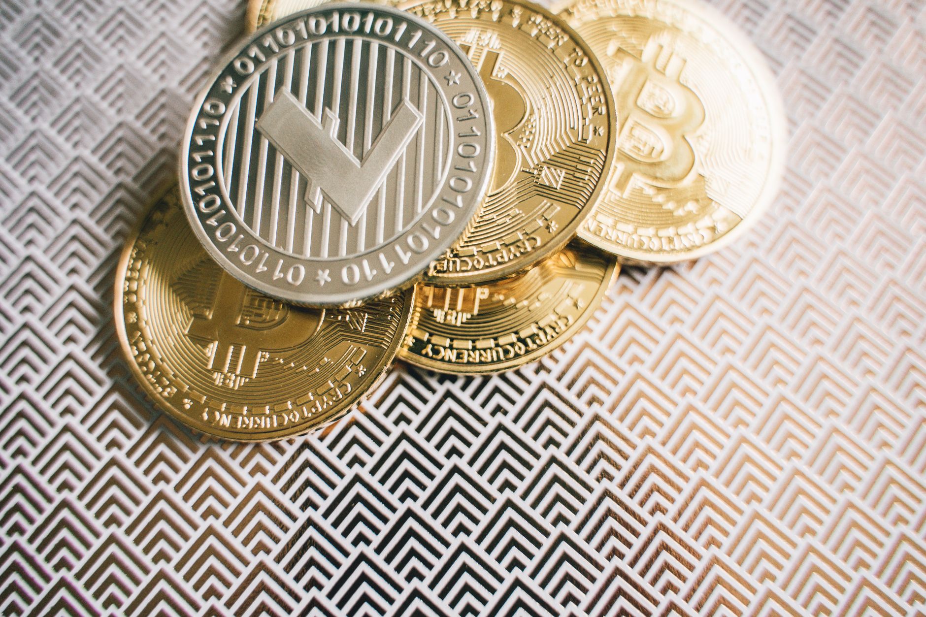 A man burns a fake dollar with a Bitcoin symbol outdoors, symbolizing cryptocurrency risks.