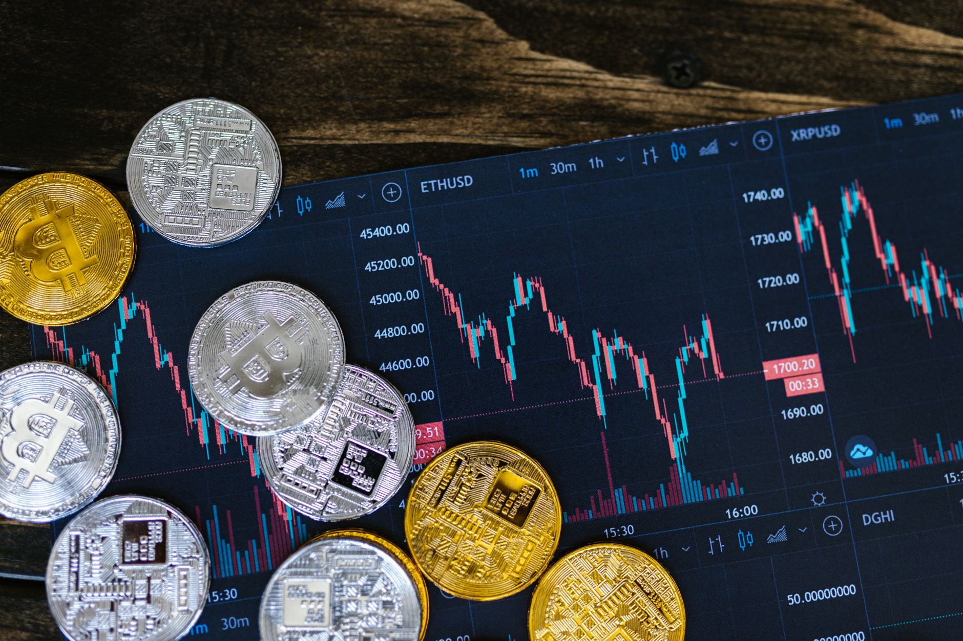 Bitcoin coin in a green pot surrounded by crypto coins on a wooden table.