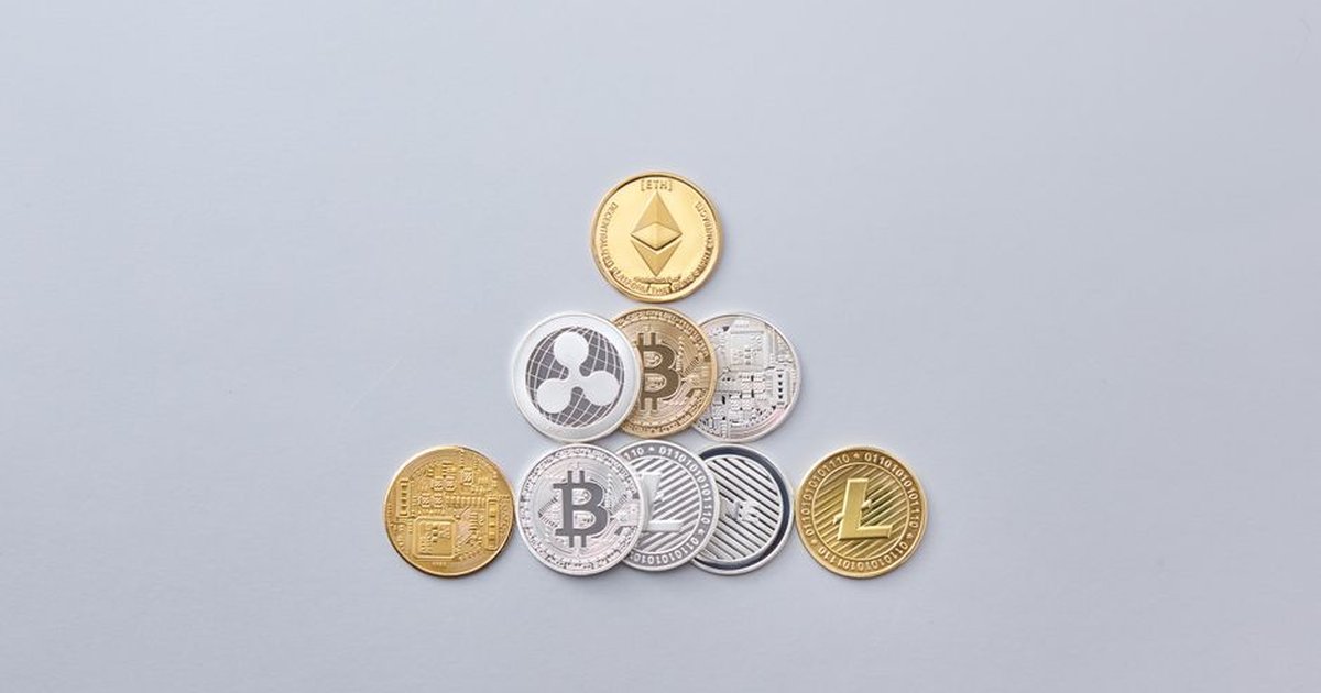 Minimalist display of cryptocurrency coins including Bitcoin and Ethereum on a gray background.