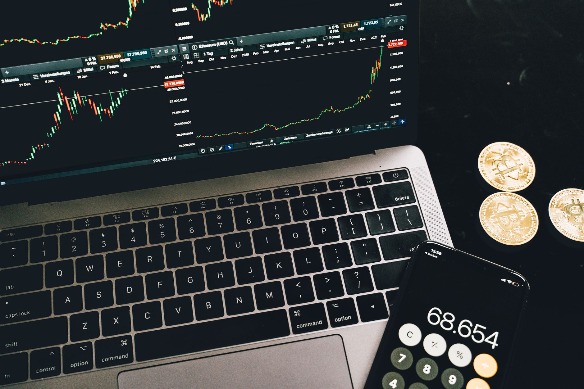 A hand holds various cryptocurrency coins including Bitcoin, Ethereum, and others.