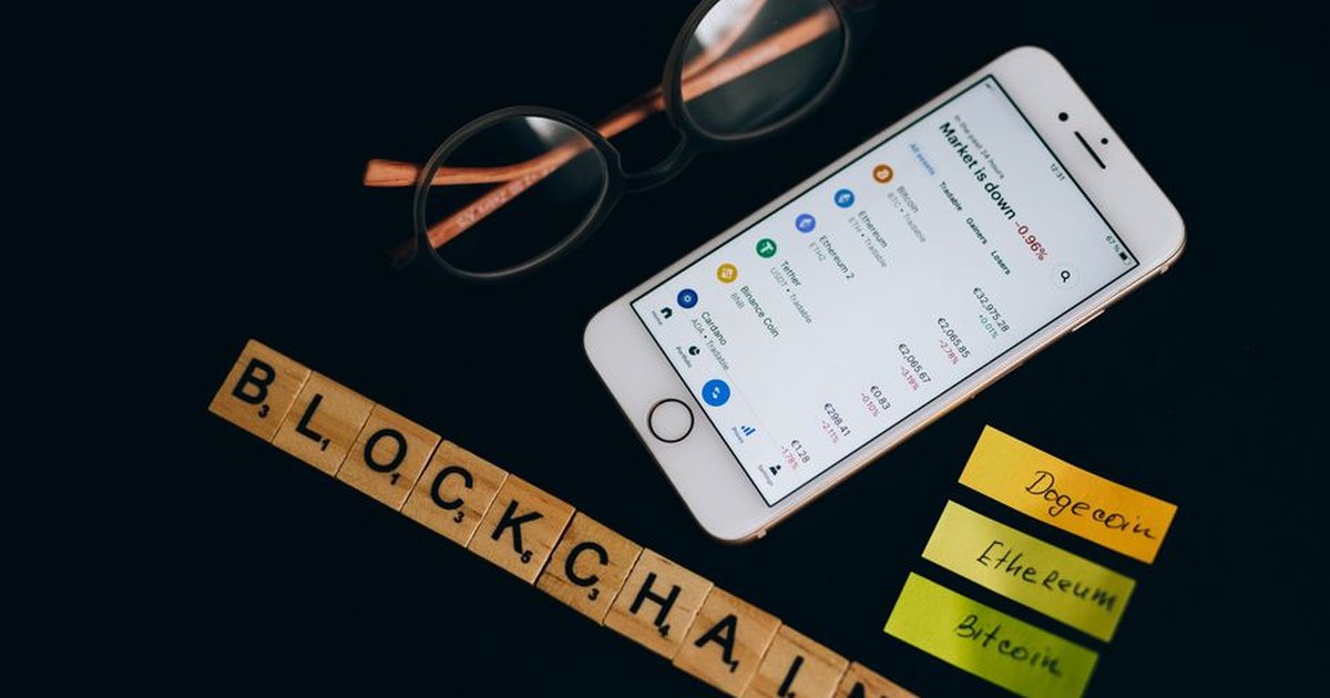 Smartphone displaying cryptocurrency market data alongside blockchain concept elements.