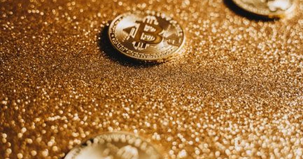 Close-up of Bitcoin coins on a shimmering gold background, representing digital currency.