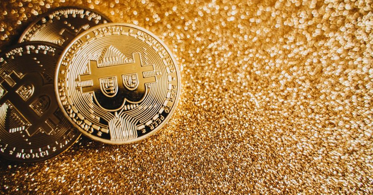 Close-up of bitcoins on a shimmering gold background, symbolizing digital wealth and investment.