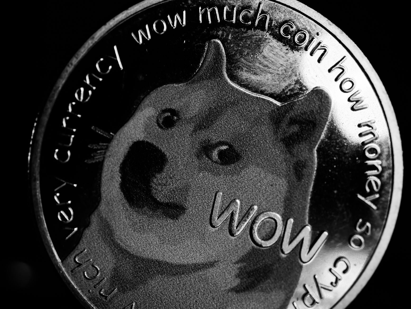 Close-up of bitcoin coins reflecting on a screen with financial market data, highlighting digital currency trend.
